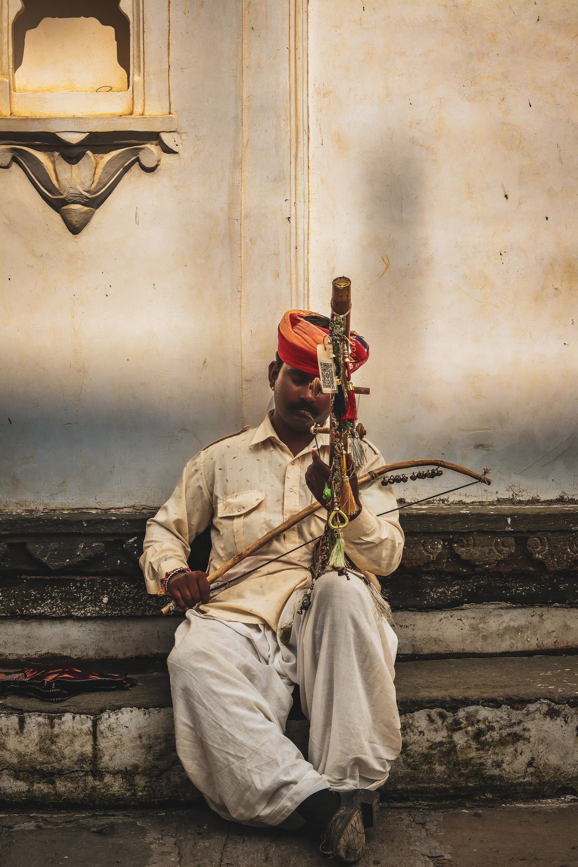 Rajasthani folk musician in a red turban playing the ravanhatta