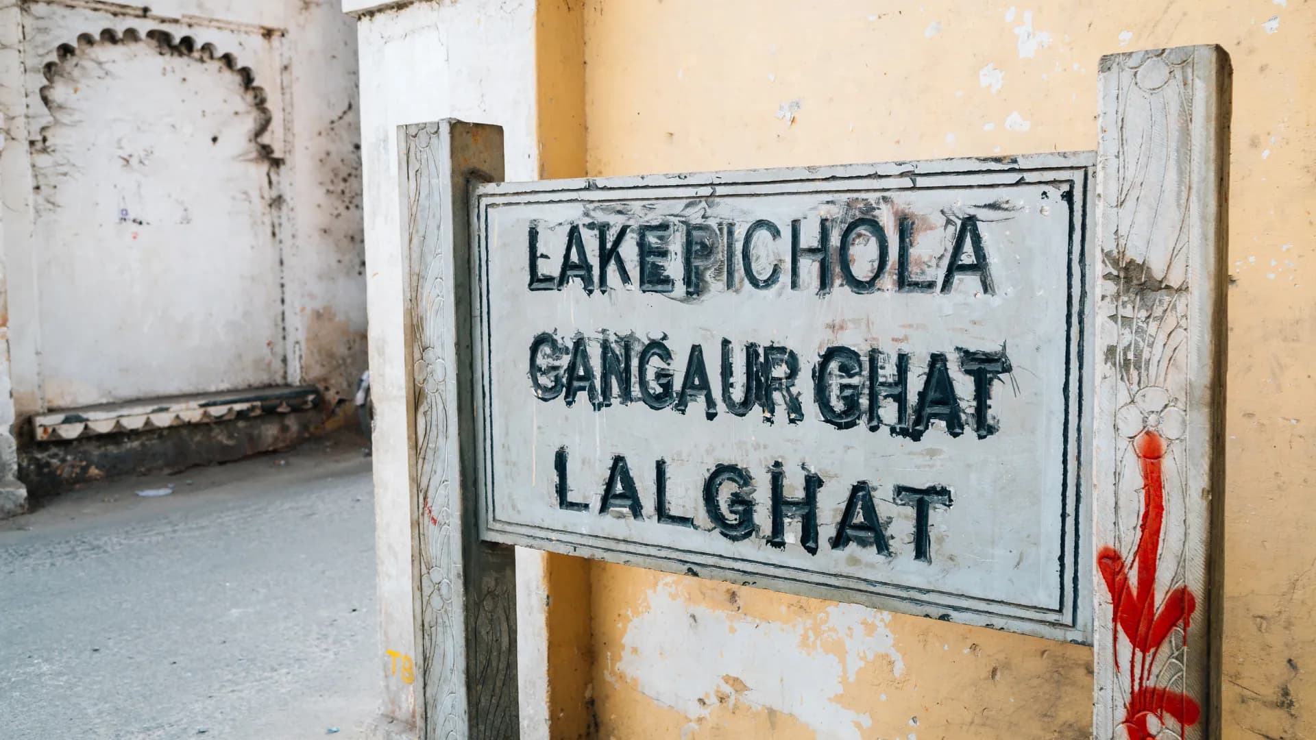 Old painted signboard pointing to Lake Pichola, Gangaur Ghat and Lal Ghat