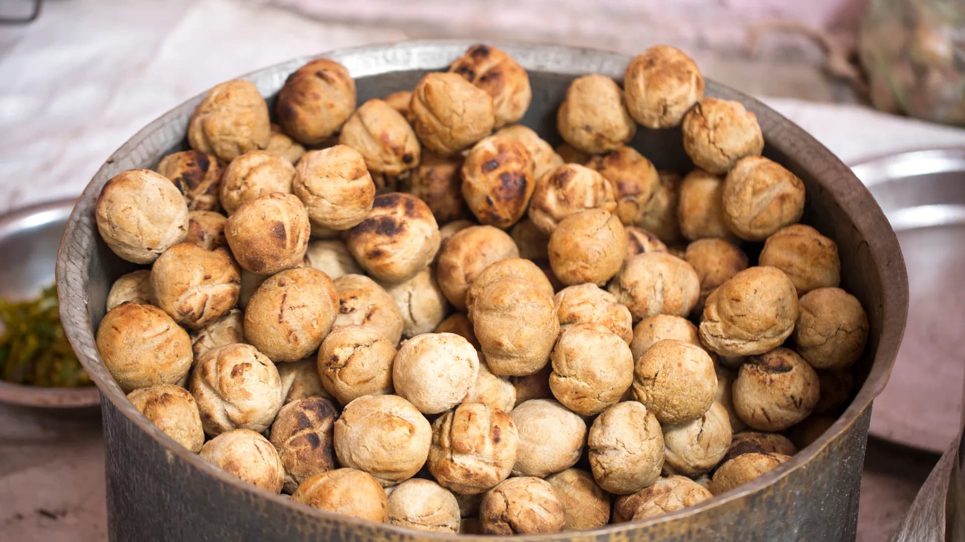 A clay pot full of freshly baked baati, a Rajasthani staple