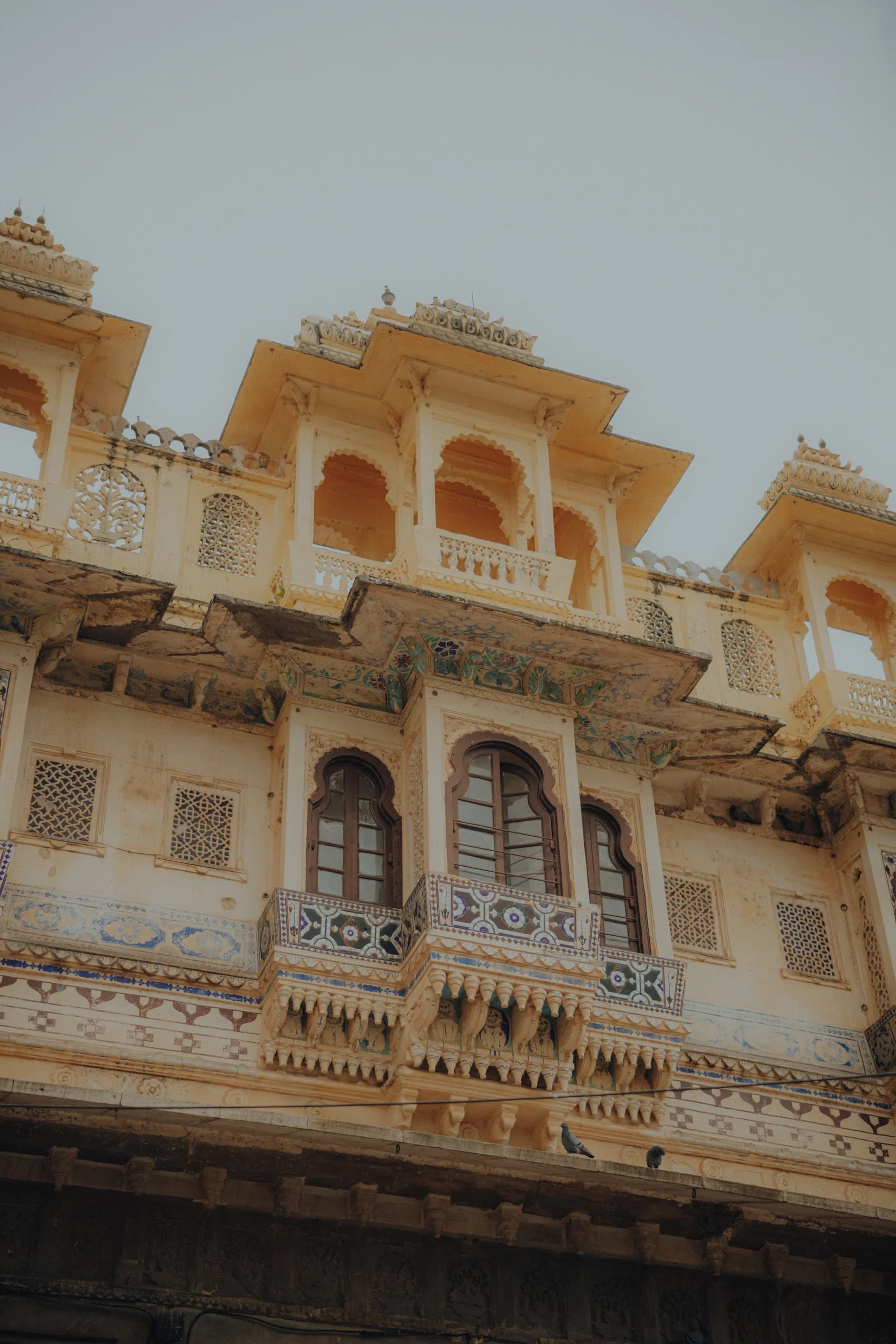 Carved stone facade with jharokha balconies in Udaipur's old city