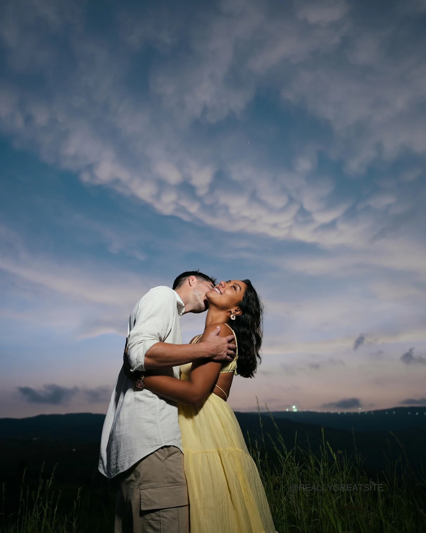 Couple embracing at dusk on a hill above Udaipur