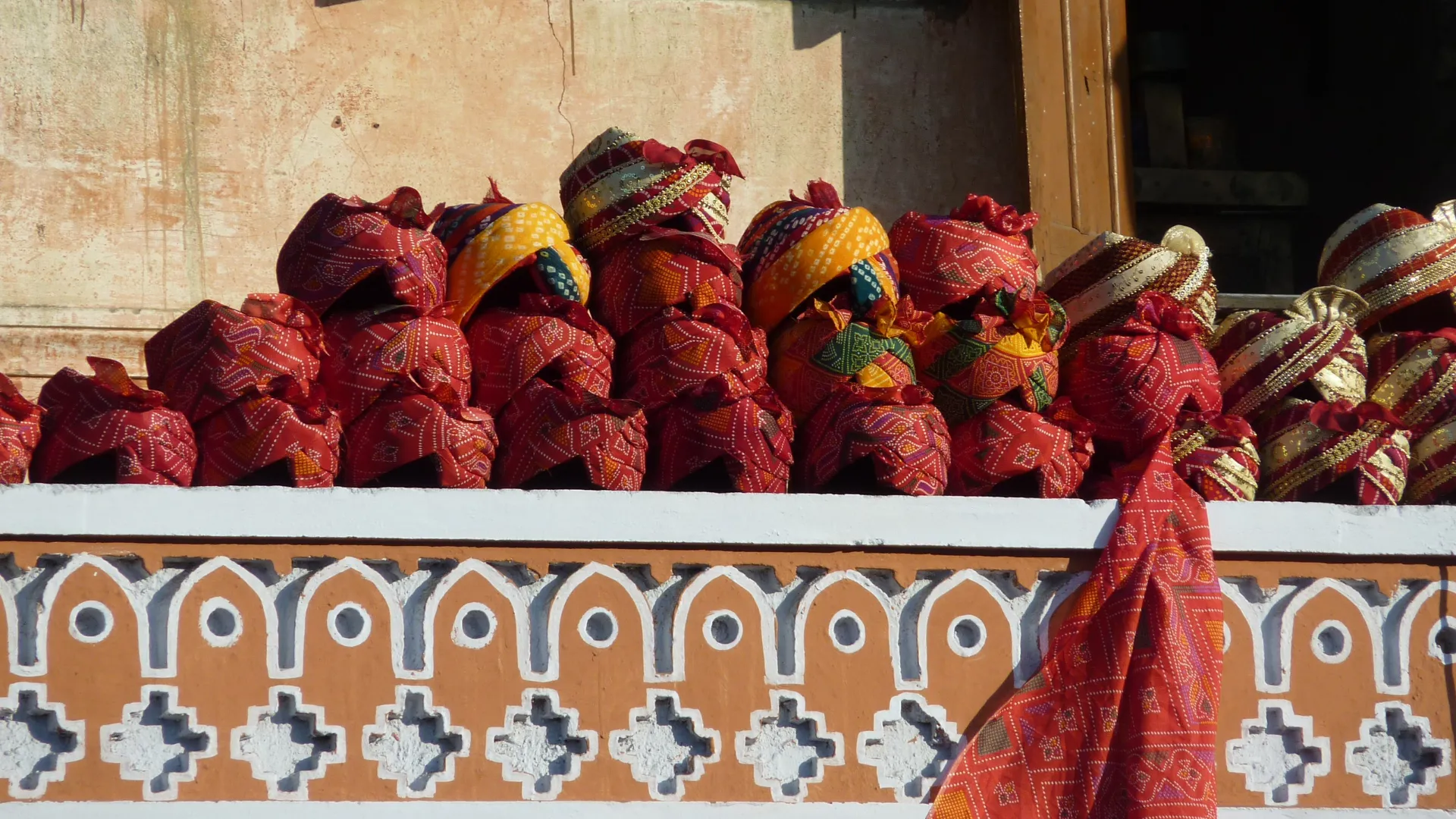 Traditional turbans and textiles stacked for sale in an Udaipur market